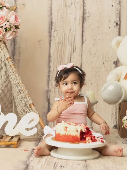 A wider shot of the cakesmash in progress, showing the baby enjoying her cake in our carefully designed studio set.