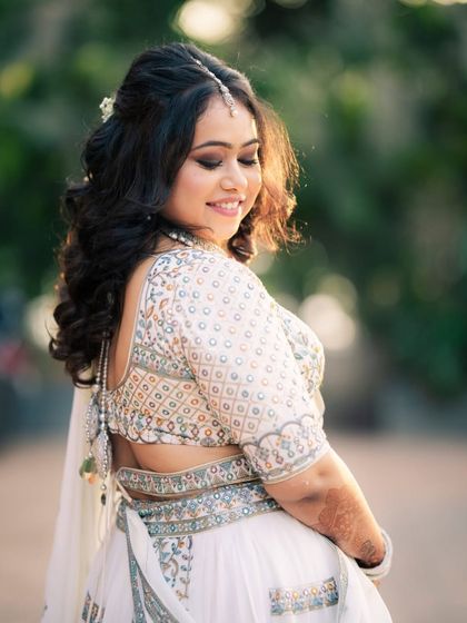 A beautiful candid shot of the bride-to-be. The soft sunlight highlights her glowing skin and the gentle waves in her hair, creating a dreamy and romantic portrait.