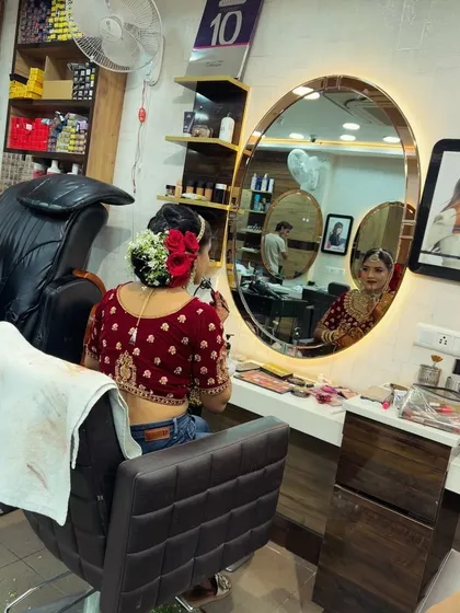 A candid moment of our bride checking her final look in the mirror. You can see our salon setup and the care we take during the getting-ready process.