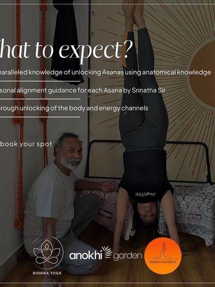 A student practices a handstand against the wall with guidance from Srinatha Sir. This image details what to expect from his workshops: personal alignment guidance and a thorough unlocking of the body's energy channels.