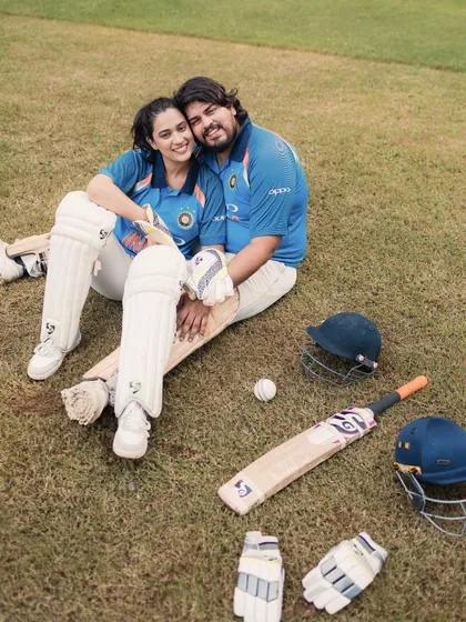 A moment of rest and connection amidst the cricket gear. This photo shows the couple's relaxed and happy chemistry, even when surrounded by bats and balls.