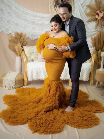 For the mama who wants to celebrate her beautiful bump, this mustard yellow mermaid gown is a showstopper. The fitted silhouette and dramatic ruffled train create a powerful and glamorous look for any maternity photoshoot.