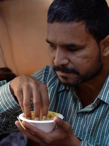 A man enjoying a wholesome Sattvik meal. Our Annam Brahma initiative ensures that the food served is not only filling but also pure and healthy, nurturing both body and soul.