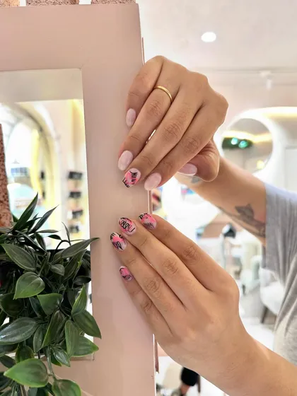 The short, oval nail shape is a great base for this punchy and modern pink and black design.