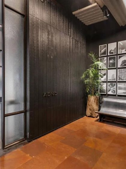 The entrance to the ADND office features a dark, moody palette with a gallery wall of the firm's work, creating a strong brand statement.