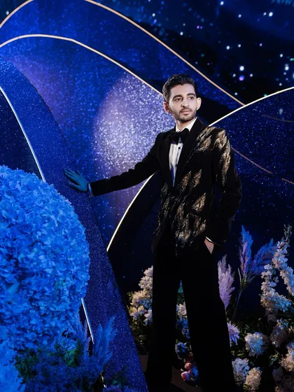 A portrait of the groom, framed by the clean lines and sparkling textures of the custom-built photo walls, showcasing the modern and sophisticated design elements.
