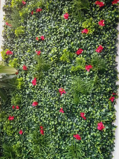 A detailed look at an artificial vertical garden setup. I mix different types of artificial leaves, grasses, and flowers to create a rich texture and a natural look. This is a popular choice for modern apartments in Bangalore.