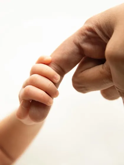 Sometimes the most powerful portraits are in the smallest details. This tiny hand holding a parent's finger tells a story of connection, trust, and unconditional love that you will cherish forever.