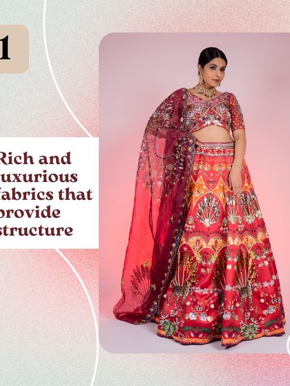 This graphic highlights the rich, luxurious fabric of one of our red bridal lehengas. The structured material gives the outfit a regal silhouette.