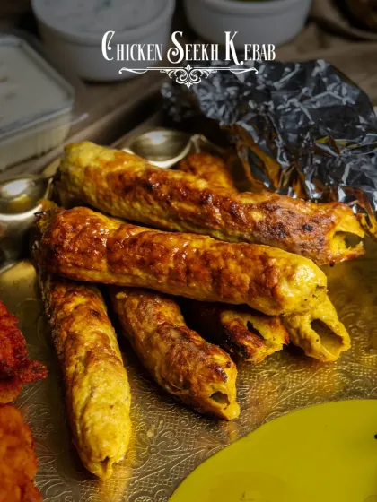 Juicy Chicken Seekh Kebabs, as featured in our Akbari Thaal. These kebabs are minced, spiced, and grilled to perfection, offering a smoky flavor and a tender bite.