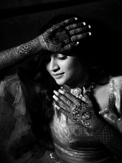 Fun and candid moments from a mehendi ceremony. The bride's makeup is fresh and playful, with a winged liner and glowing skin, perfect for celebrating with her loved ones. The hairstyle is a soft half-updo with pretty accessories.
