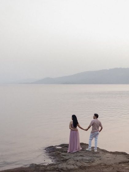A couple holding hands and looking out at the calm waters of Pawna Lake. This image evokes a sense of shared dreams and a peaceful journey together, making it a meaningful pre-wedding portrait.