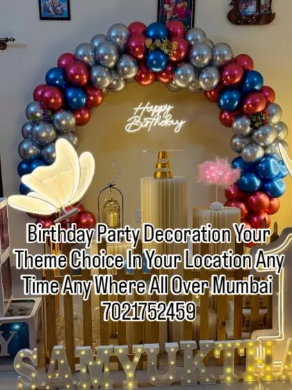 A modern butterfly theme for Samyukta's first birthday. This decoration features a stylish wooden backdrop, light-up butterflies, marquee letters, and a red, blue, and silver balloon arch.
