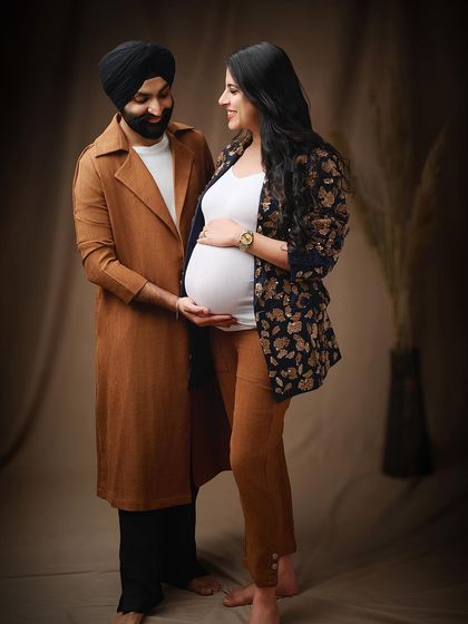 This stylish couple's portrait showcases a more contemporary and fashionable approach. The coordinated outfits and warm studio lighting create a chic and modern memory.