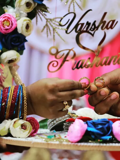 The ring exchange is a pivotal moment. We focus on capturing these important details, like this shot of the engagement rings with the couple's names elegantly displayed in the background.