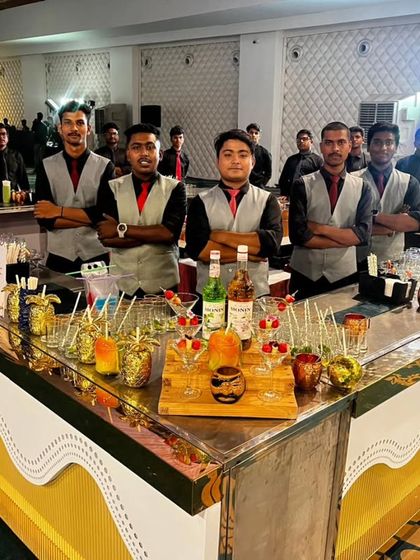 Our team ready for service behind a fully stocked and garnished bar at a large wedding event. We can set up long counters to ensure quick and efficient service for a large number of guests.