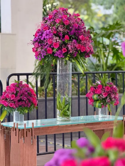 More views of the contemporary console tables adorned with large, vibrant floral arrangements, set against the backdrop of the city skyline.