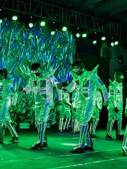 A troupe of LED dancers performing on stage, creating a vibrant and futuristic visual spectacle for the guests.