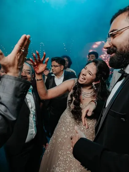 A candid moment of the bride and groom dancing together amidst their friends.