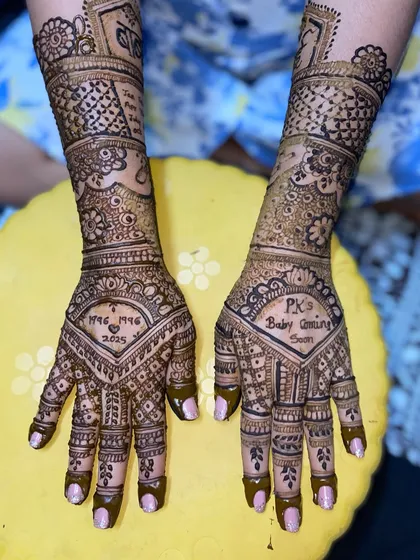 A personalized design incorporating the couple's initials 'P.K.'s Baby Coming Soon' and their anniversary date, blending personal details with traditional mehandi art.