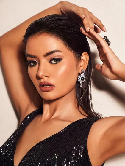 A strong and confident pose. The sharp eyeliner and sculpted cheeks create a powerful look that is both modern and timeless.