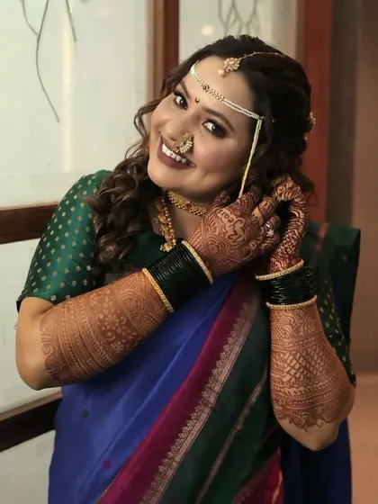 A close-up of the bride getting her finishing touches. Her smile shows her confidence and happiness with the final look, which is my ultimate goal.
