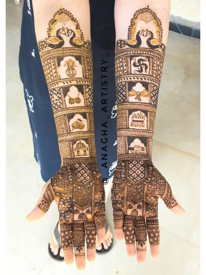 A full view of a bride's arms, showcasing the symmetry and detail in my work. The design features peacocks at the top and panels of traditional wedding symbols below.