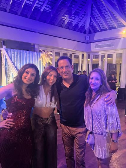 Celebrating a friend's 50th birthday in style. I'm wearing a custom-designed white halter top and shimmering gold trousers.