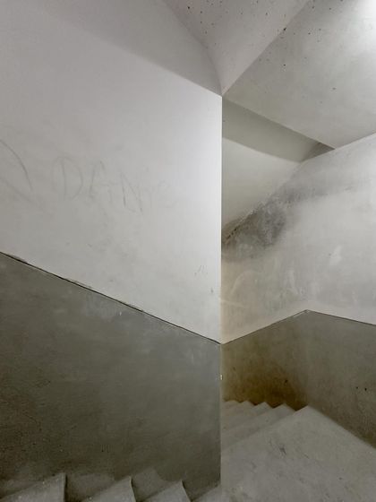 The abstract geometry of intersecting planes in a concrete stairwell.