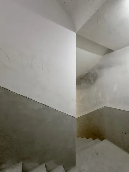 The abstract geometry of intersecting planes in a concrete stairwell.