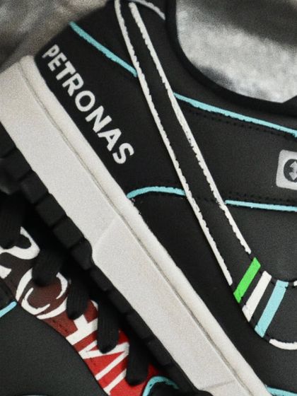 A close-up of the Mercedes F1-themed Dunks, showing the hand-painted Petronas logo. Precision is key for these designs to ensure every detail is crisp and authentic.