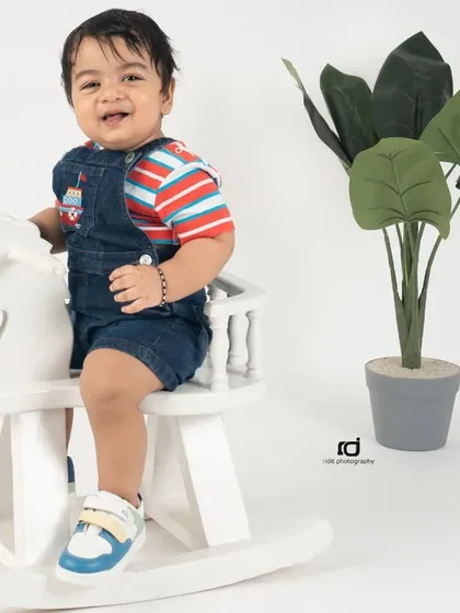 A big smile from the birthday boy. This simple and happy shot on a rocking horse captures the cheerful spirit of a one-year-old.