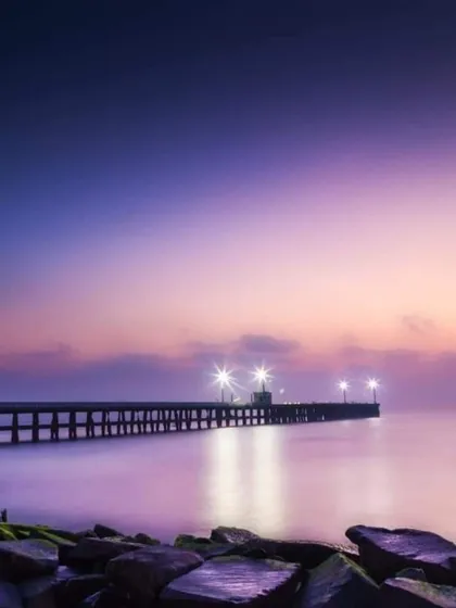 The serene beauty of the Promenade Beach pier in Pondicherry at dusk. It's the perfect place to unwind after a day of exploring the charming French-inspired streets and local cafes.