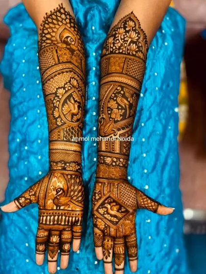 This design is a symphony of peacocks, with the majestic bird featured in various forms from the palm to the elbow. The use of negative space makes the motifs stand out beautifully.