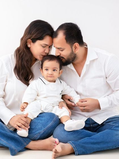 An intimate family moment, heads together, focused on their little one. This pose creates a powerful feeling of unity and love.