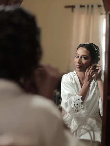 Getting ready in her silk robe. This behind-the-scenes moment shows the bride looking fresh and beautiful even before she puts on her gown.