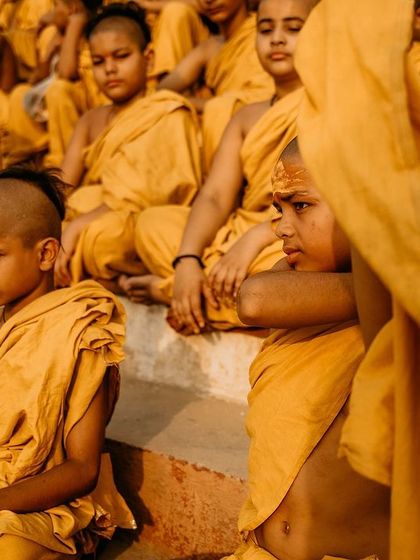 A group of young Batuks sit and listen during a lesson on the ghats. The frame is filled with their focused expressions, showing the discipline of their spiritual education.
