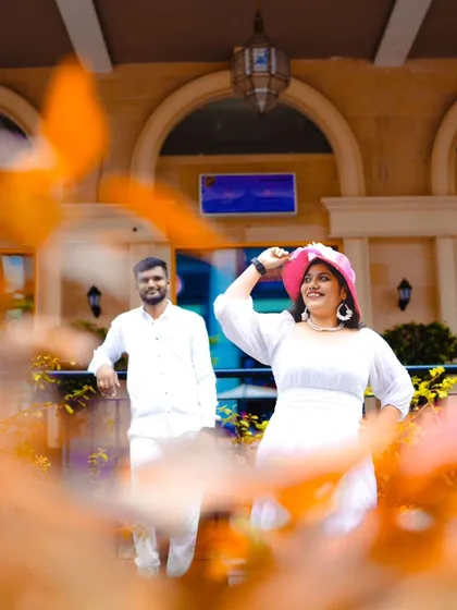 A candid and happy shot of the couple in a modern urban setting. The bride's pink hat adds a fun pop of color.
