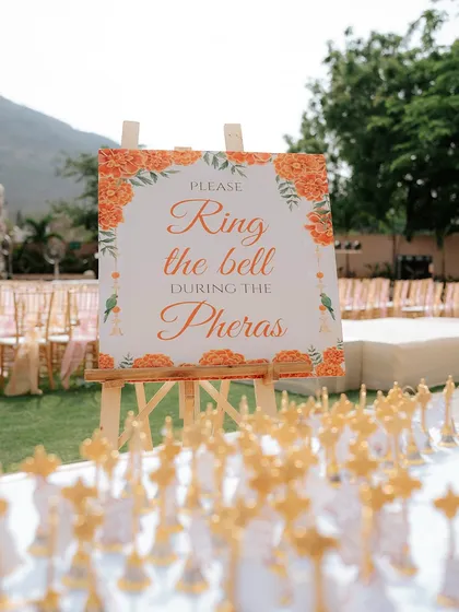 A creative touch for the ceremony: a sign asking guests to "Ring the bell during the Pheras," with bells provided for everyone to participate in the celebration.