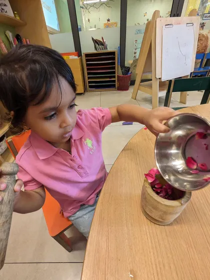 For Mother's Day, children engaged in a multi-sensory culinary project. They scooped aloe vera gel and crushed rose petals to create a special gift. This practical life skill activity also involves measuring, pouring, and mixing.
