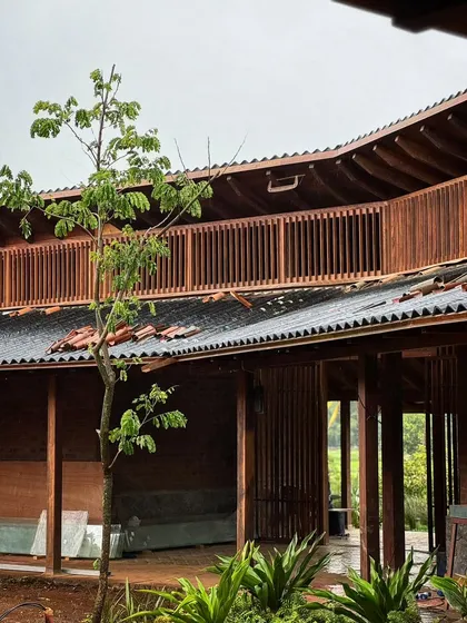The intricate woodwork of the upper-level balcony at the Kamshet farmhouse. The vertical timber screens provide privacy and shade while allowing for cross-ventilation, a key element of our passive cooling strategy.