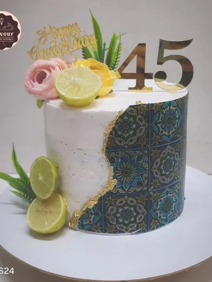 A refreshing lemon cake with lemon mousse filling, made to celebrate a 45th anniversary. The cake is decorated with a beautiful tile print and fresh lemons.