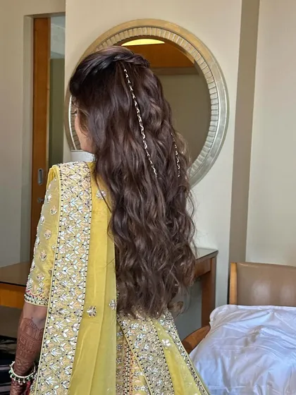 A simple yet stunning half-up twist with loose waves. The delicate hair chains add a touch of modern elegance, perfect for a Haldi or Mehendi ceremony.