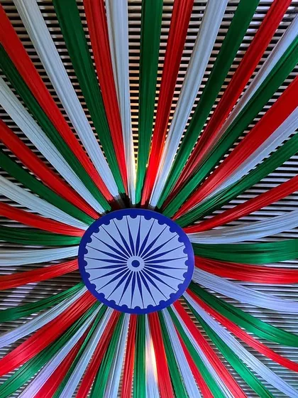 A stunning ceiling decoration for a national event. I used saffron, white, and green fabric strips to create a massive canopy radiating from a central Ashoka Chakra.