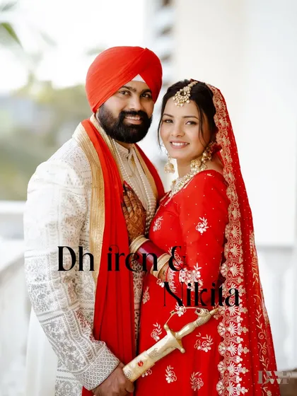 A classic portrait of the smiling Punjabi couple, showcasing their beautiful red and white wedding outfits.