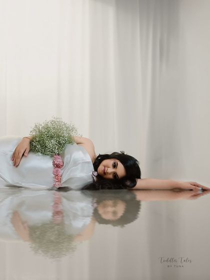 A reflection of dreams. This artistic shot uses a reflective surface to create a perfectly symmetrical, almost surreal image of the mother-to-be, evoking a sense of peace and introspection.