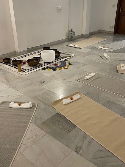 The serene setup for our Sound Healing workshop. We create a calm and inviting space with mats, bolsters, and singing bowls, ready for you to relax and receive the healing vibrations.