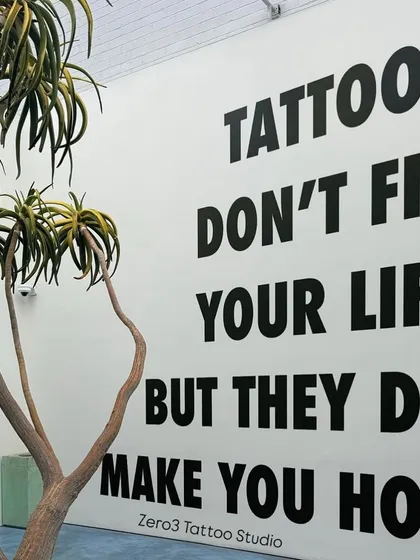 A shot of a wall in a studio that says it all: "Tattoos don't fix your life but they do make you hot."