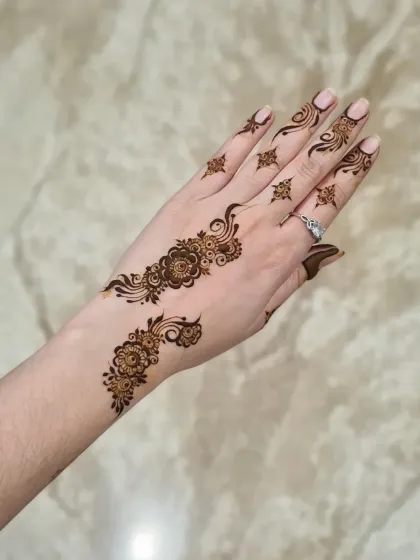 A very simple and delicate floral vine on the back of the hand. Perfect for someone trying henna for the first time or who prefers a minimal look.