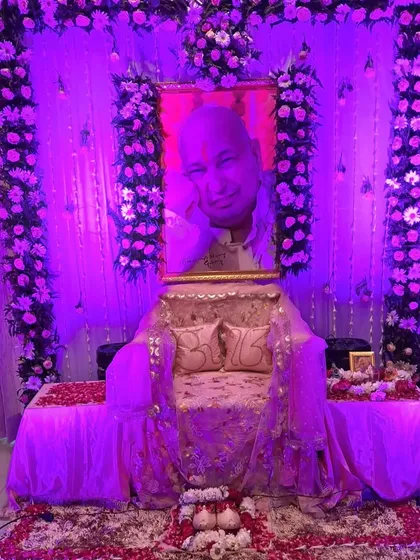 This image shows how lighting can transform a space. It is the same satsang decoration as a previous photo, but illuminated with purple light to create a different, more meditative mood for an evening event.